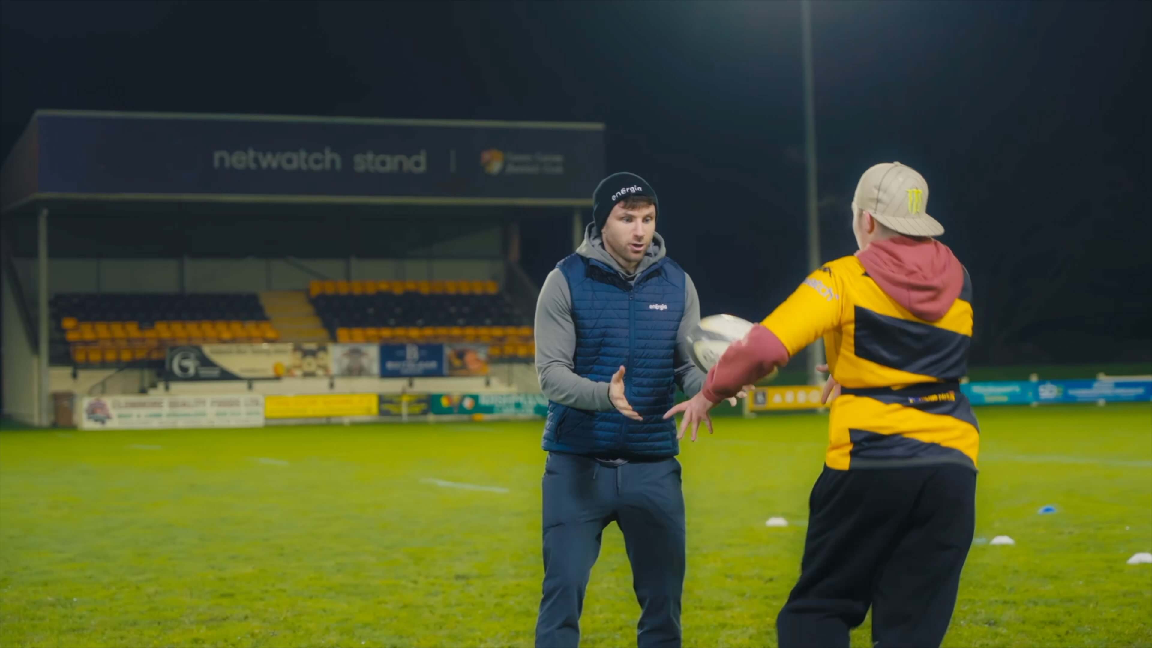 Hugo Keenan on the pitch with a Calrow Bees player passing the ball to each other.