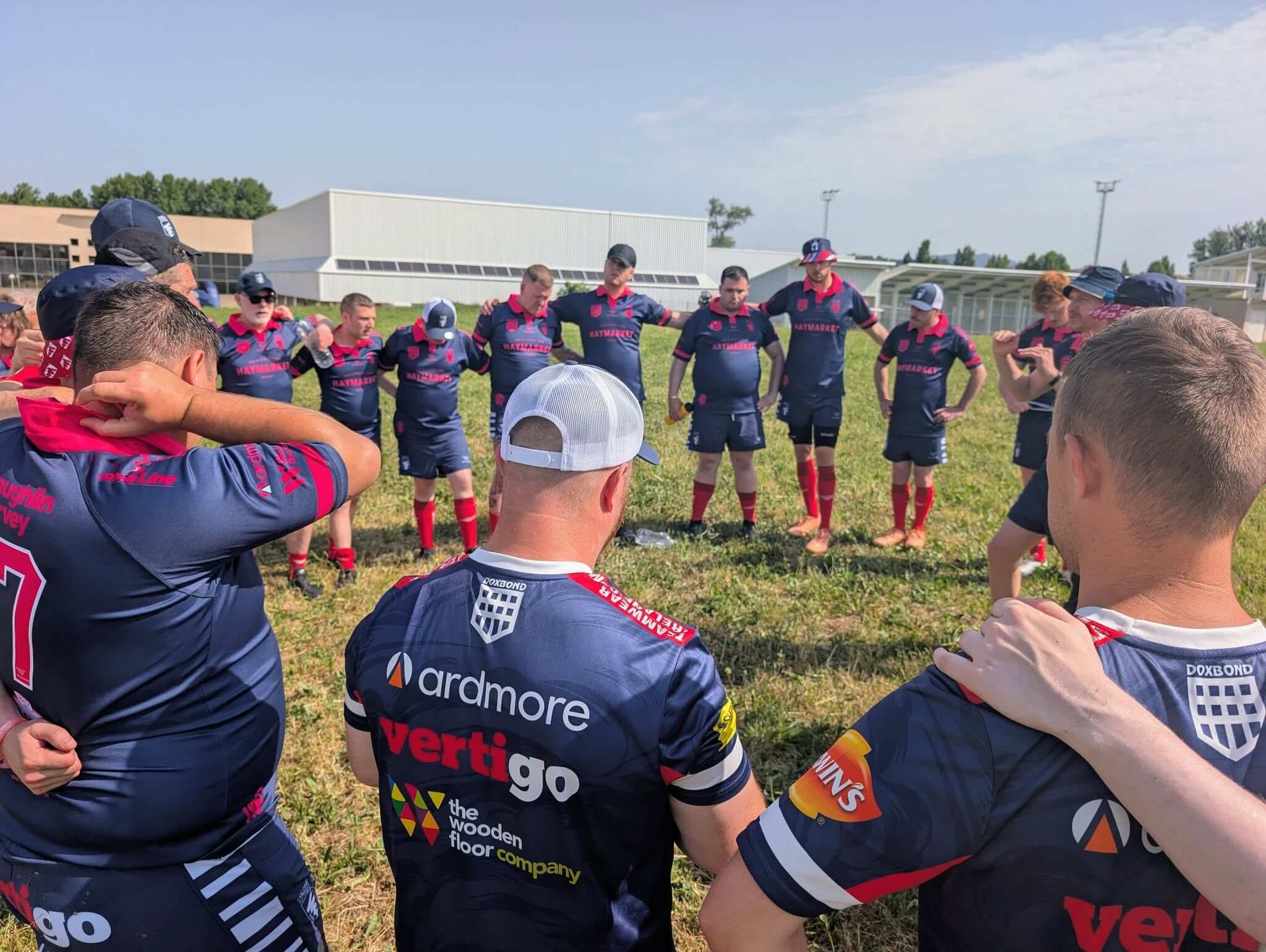 Malone Tornadoes players in a circle on the pitch