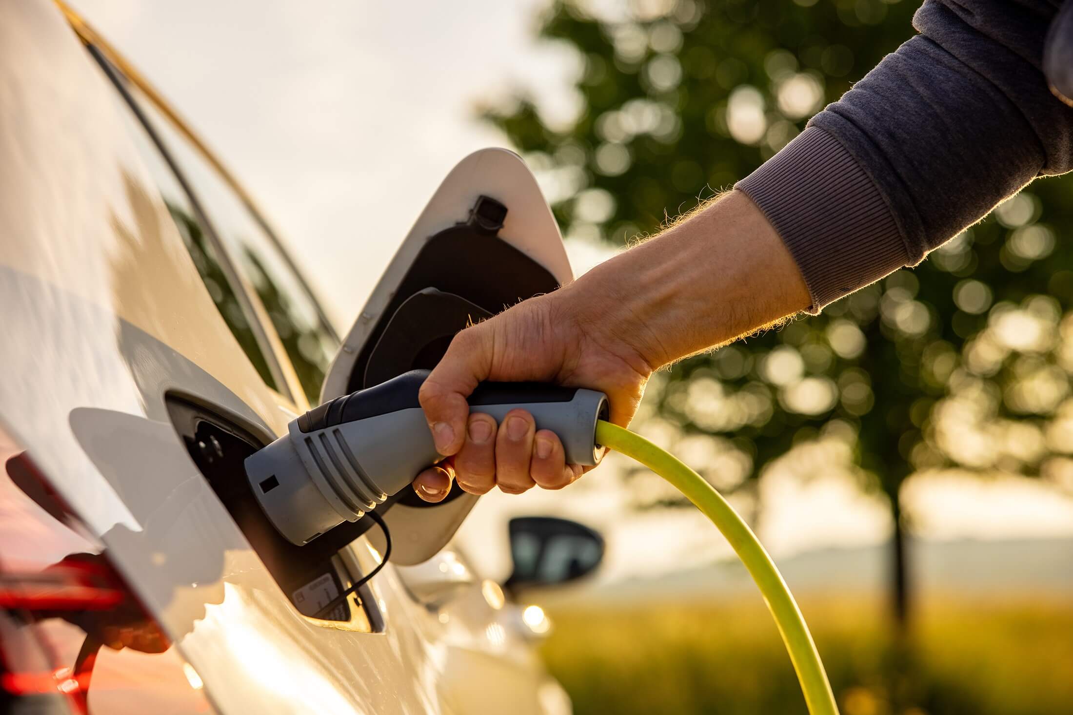 Person plugging in electric car.